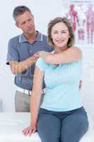 Woman stretching her arm with her doctor