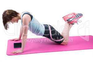 Pretty brunette doing press up on fitness mat