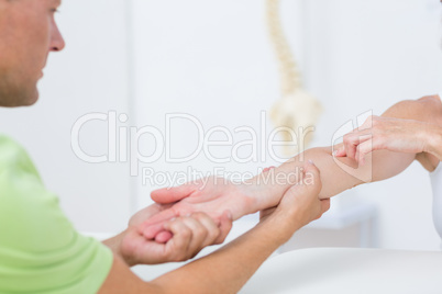 Doctor examining his patients arm