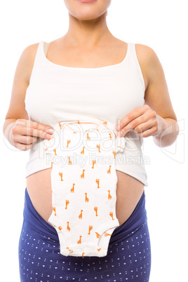 Pregnant woman holding baby clothes