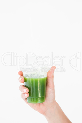 Woman showing green juice in goblet