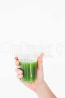 Woman showing green juice in goblet