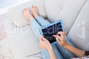 Woman using tablet computer on couch