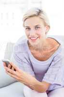 Pretty blonde woman texting with her mobile phone