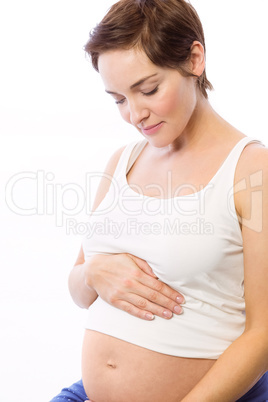 Pregnant woman smiling at bump