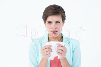 Sick woman holding a tissue and looking at camera