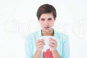 Sick woman holding a tissue and looking at camera