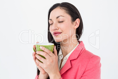 Smiling brunette smelling her coffee