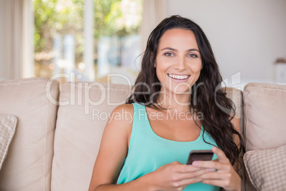 Pretty brunette texting with her smartphone