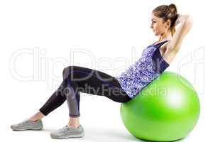 Fit woman doing sit ups on exercise ball