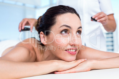 Smiling brunette getting hot stone massage