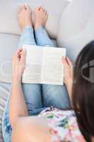 Pretty brunette reading on couch