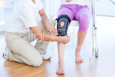 Doctor examining her patients knee