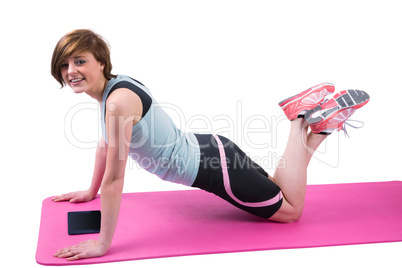 Pretty brunette doing press up on fitness mat