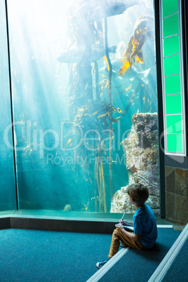 Young man drawing a fish in a tank