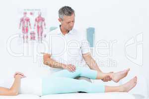 Physiotherapist doing leg massage to his patient