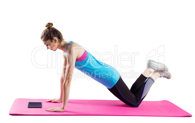 Fit woman doing press up on mat