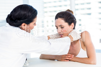 Doctor examining her patients neck