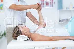 Doctor bending his patient arm