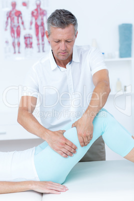 Physiotherapist doing leg massage to his patient