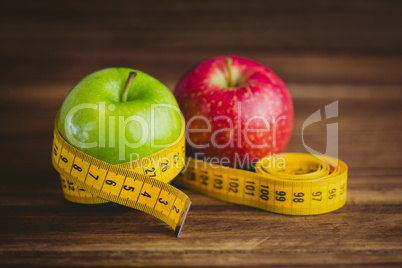 Green and red apples with measuring tape