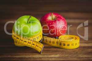 Green and red apples with measuring tape