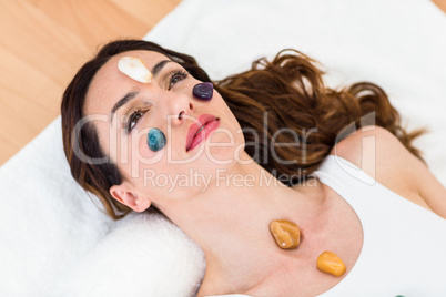 Relaxed brunette lying on mat with stones