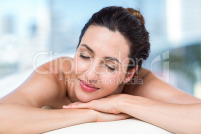 Smiling brunette relaxing on massage table