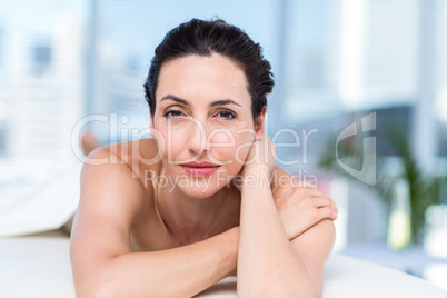 Smiling brunette relaxing on massage table