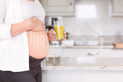 Pregnant woman drinking glass of orange juice