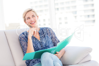 Pretty blonde woman taking notes on the couch