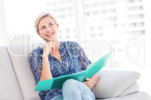 Pretty blonde woman taking notes on the couch