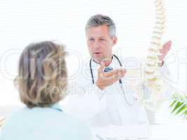 Doctor showing spine model to his patient