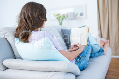 Woman reading book on couch