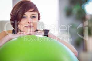 Fit woman leaning on exercise ball