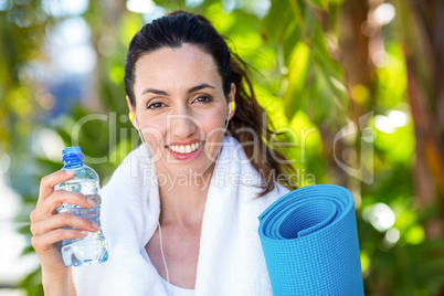 Fit beautiful brunette looking at camera while listening music