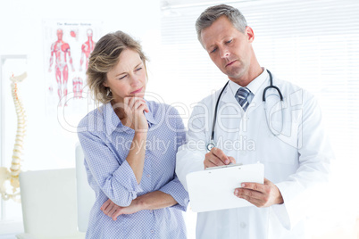 Doctor showing his notes to his patient