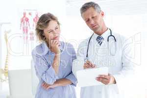 Doctor showing his notes to his patient