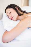 Pretty brunette sleeping on bed