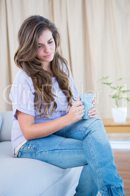 Thoughtful brunette holding cup of coffee