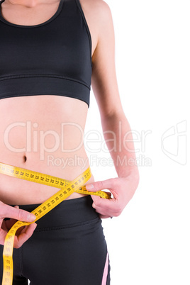 Slim woman measuring waist with tape measure