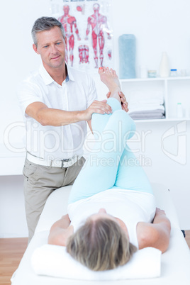 Physiotherapist doing leg massage to his patient