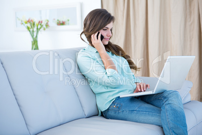 Pretty woman on the phone using her laptop