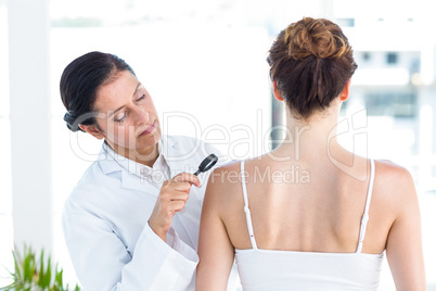 Doctor examining patient with magnifying glass