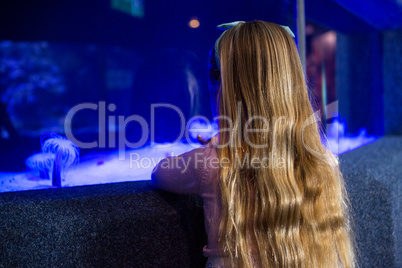 Woman looking at sea anemone in tank