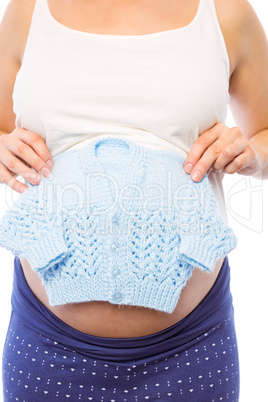 Pregnant woman holding baby clothes