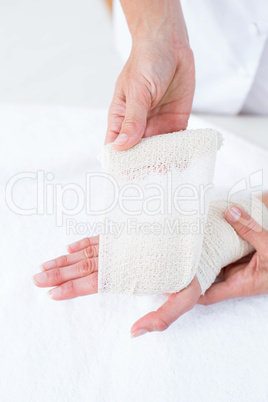 Doctor bandaging her patient wrist