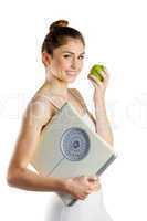 Slim woman holding scales and apple