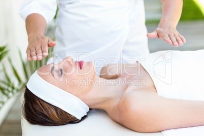 Calm woman receiving reiki treatment