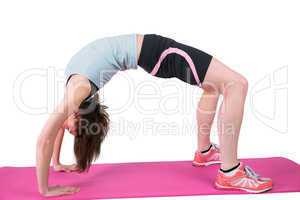 Pretty brunette stretching on exercise mat